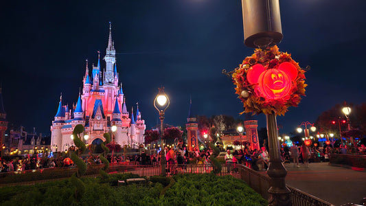 Mickey pumpkin lit up with Cinderella Castle in the background