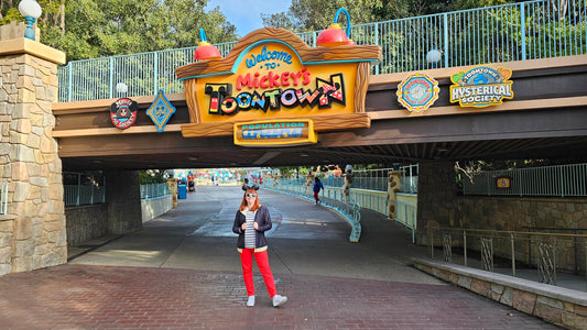 Kelly bounding as Mickey Mouse in front of the Toontown sign in Disneyland