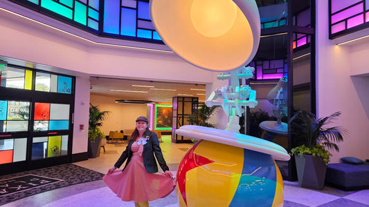 Kelly bounding as Bing Bong next to the Pixar lamp at Pixar Place Hotel