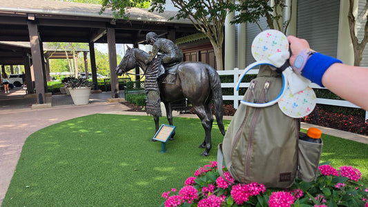 Kelly’s park bag with a set of Minnie Ears attached in front of the Jockey statue at Disney’s Saratoga Springs Resort & Spa