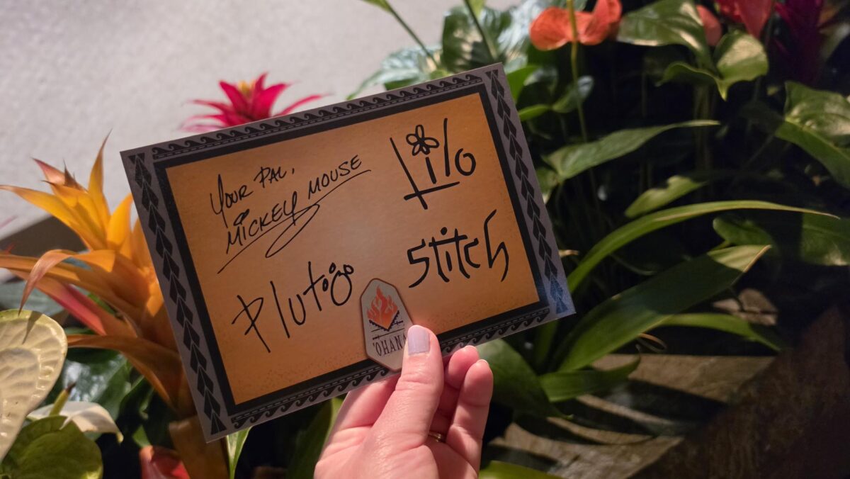 ‘Ohana postcard with signatures from Mickey, Pluto, Lilo and Stich in front of tropical flowers at ‘Ohana restaurant