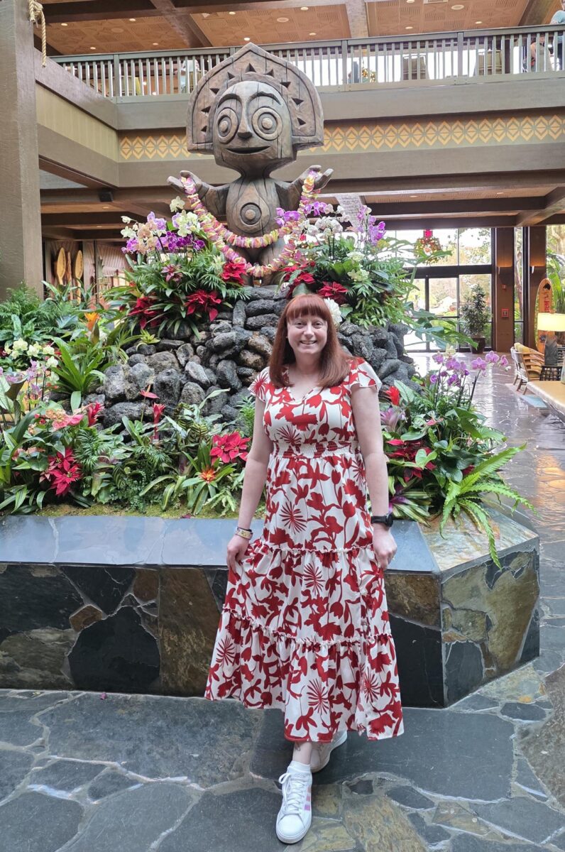 Kelly in a Lilo bound standing in front of the statue in the lobby of Disney’s Polynesian Village Resort