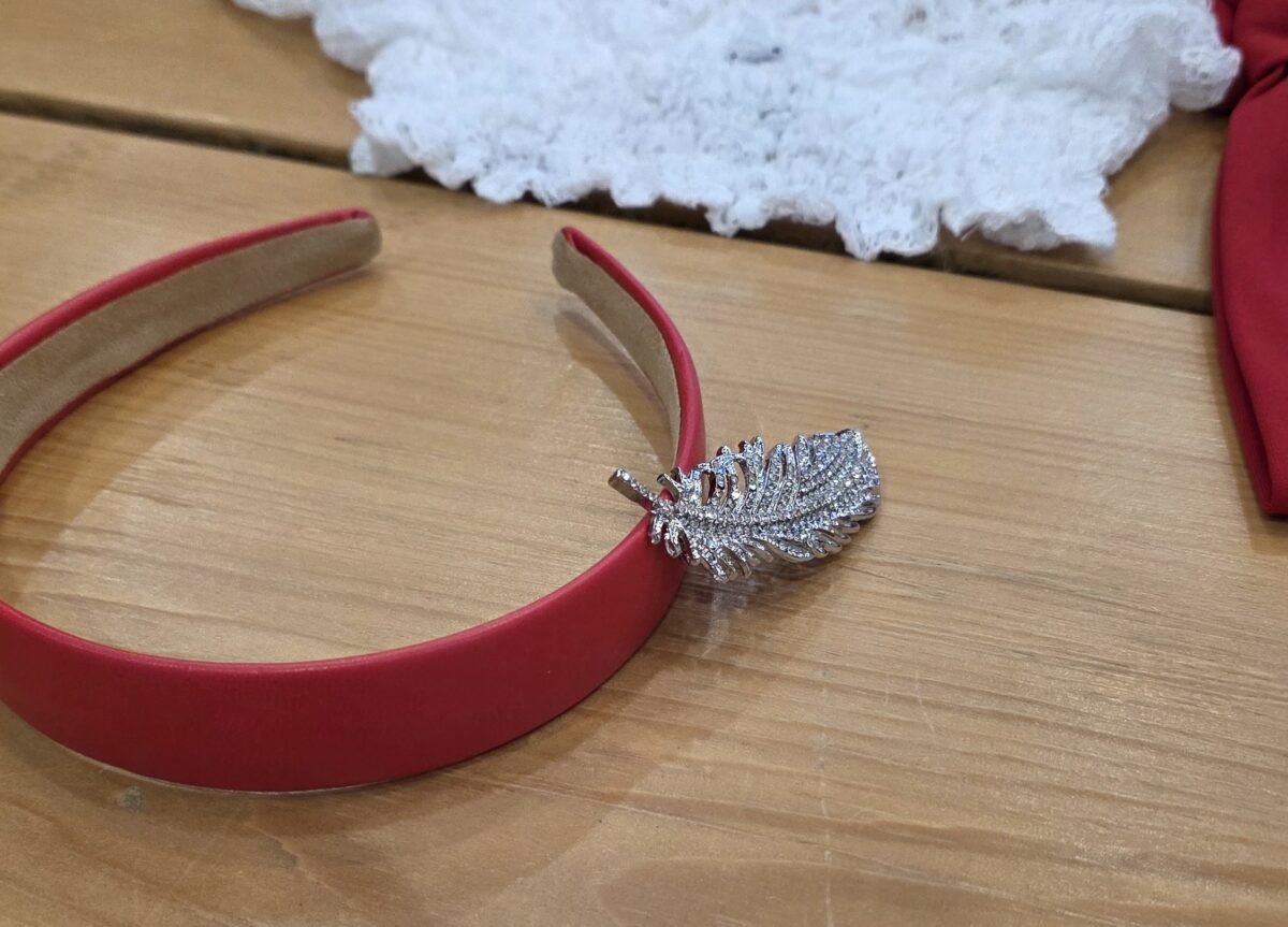 Detailed shot of red headband and feather pin for Captain Hook bound