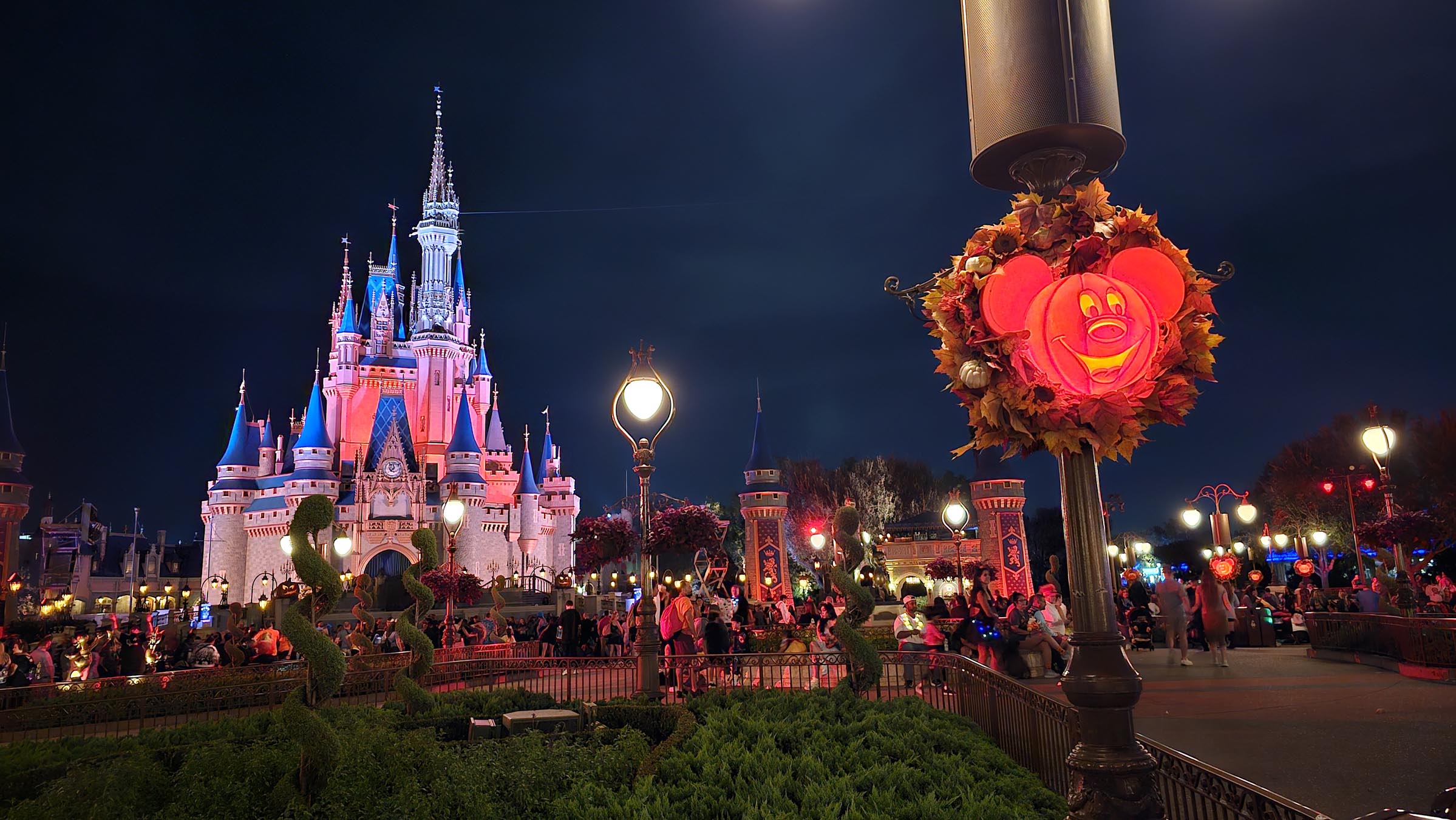 Mickey pumpkin lit up with Cinderella Castle in the background