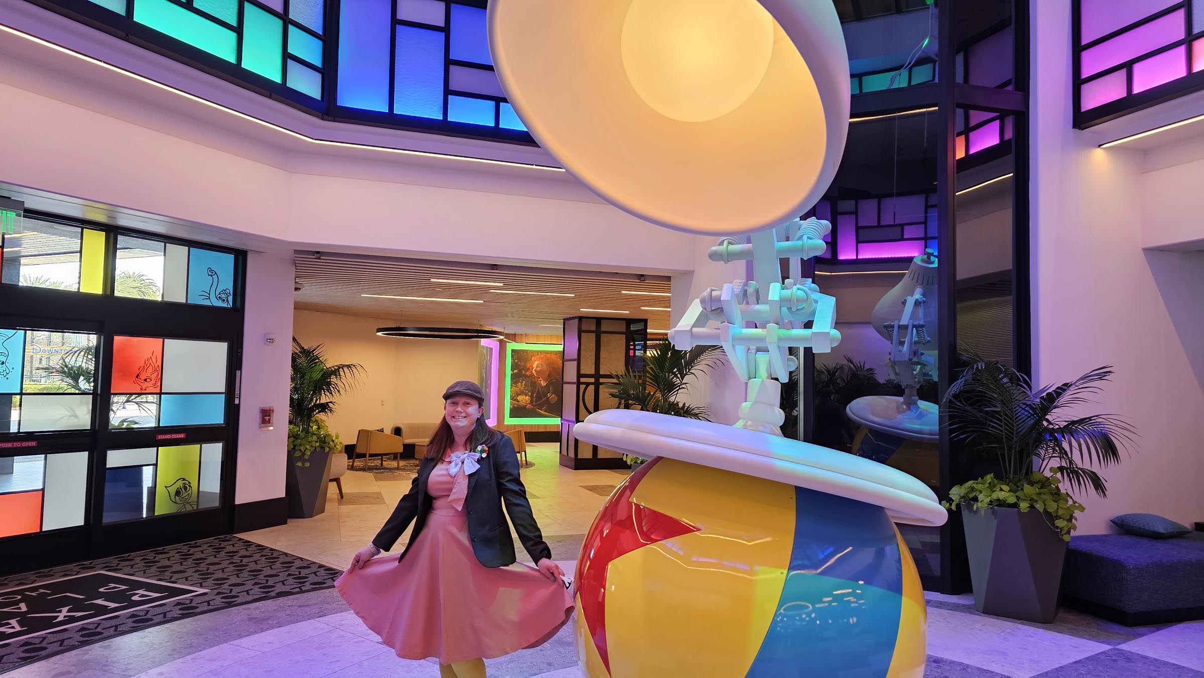 Kelly bounding as Bing Bong next to the Pixar lamp at Pixar Place Hotel