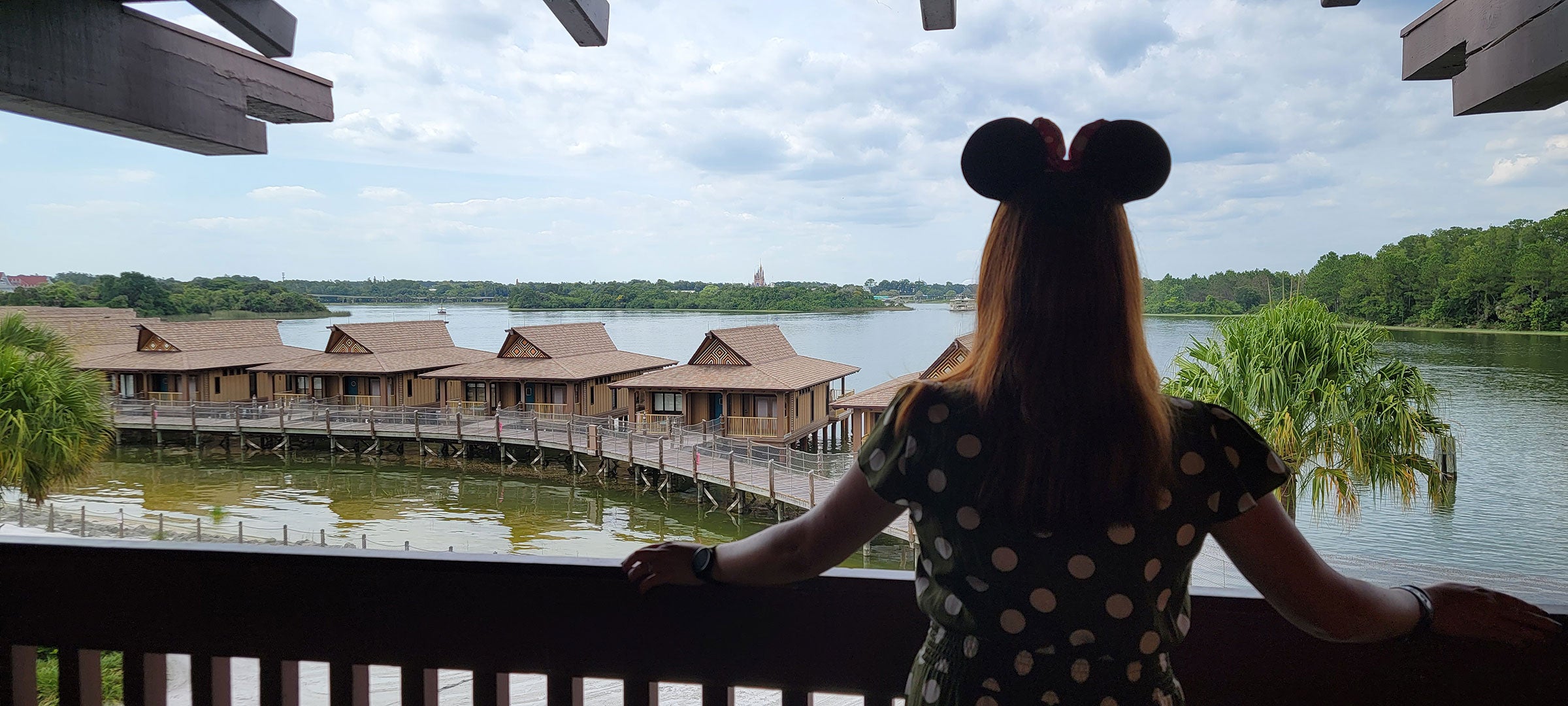 Kelly in Minnie Ears looking out at the Seven Seas Lagoon towards Magic Kingdom