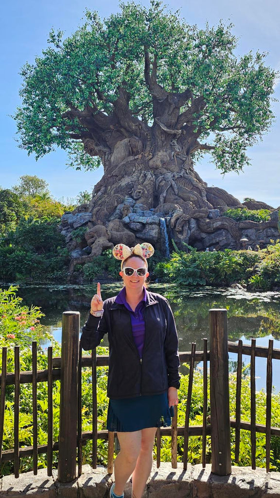 Kelly in front of the Tree of Life showing 1 finger for the first park