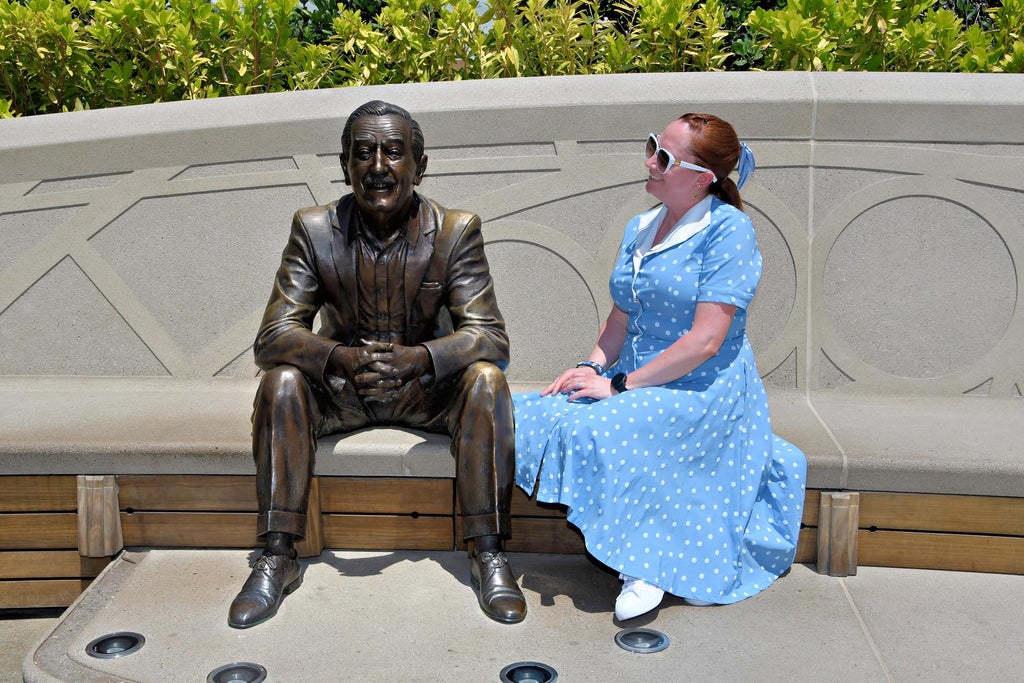 Kelly bounding as Dapper Belle next to the Walt statue in Epcot