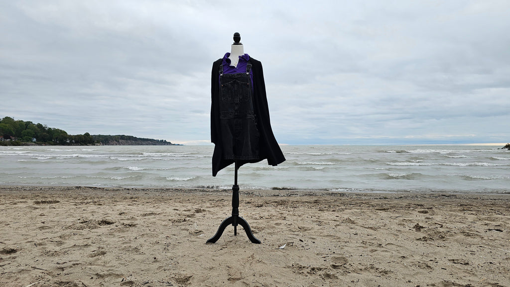 Ursula bound on mannequin at a beach with sand and water in the background
