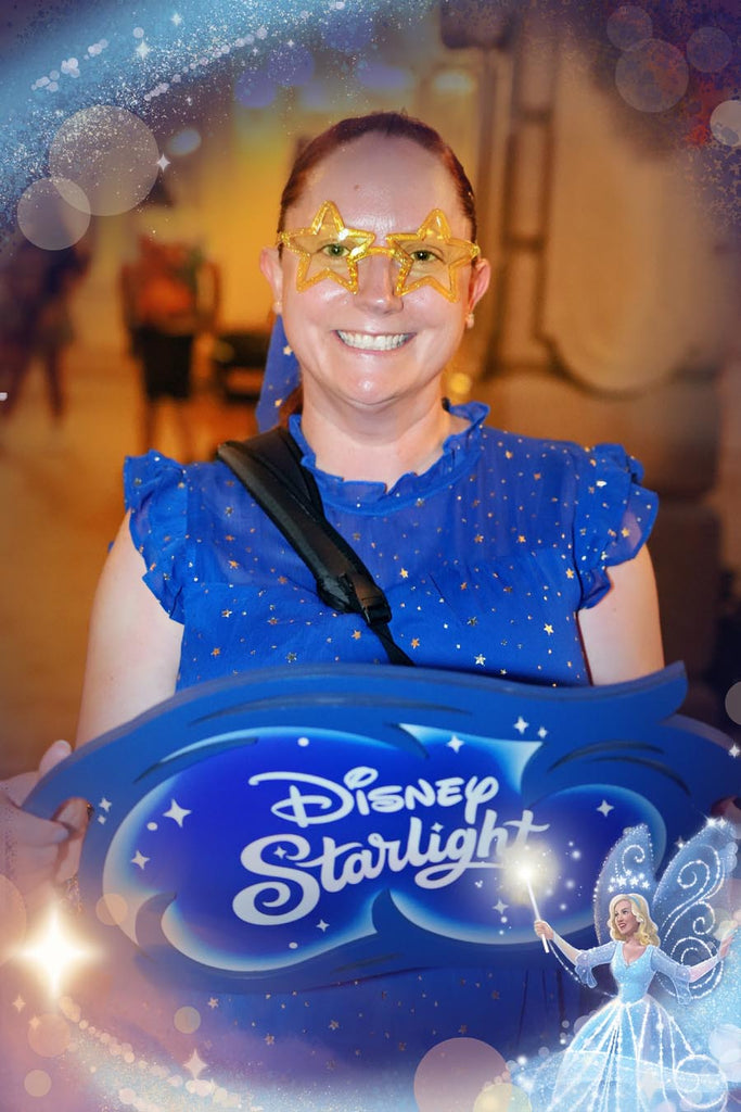 Kelly bounding as the Blue Fairy with a sign for the Disney Starlight parade