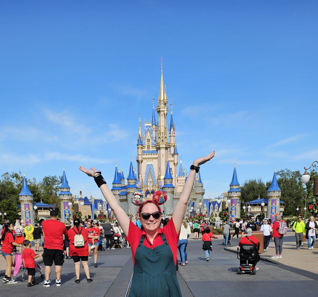 Kelly wearing holiday ears in front of Cinderella Castle at Magic Kingdom