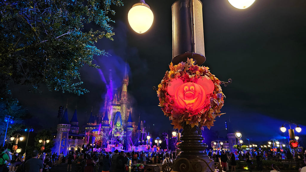 Mickey Pumpkin Wreath handing on a light pole at Magic Kingdom with Cinderella Castle in the background