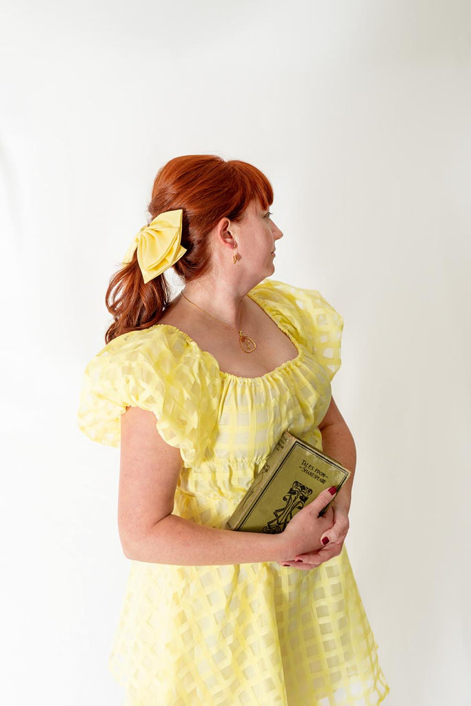 Kelly bounding as Book Loving Princess while holding a “Tales from Shakespeare” book