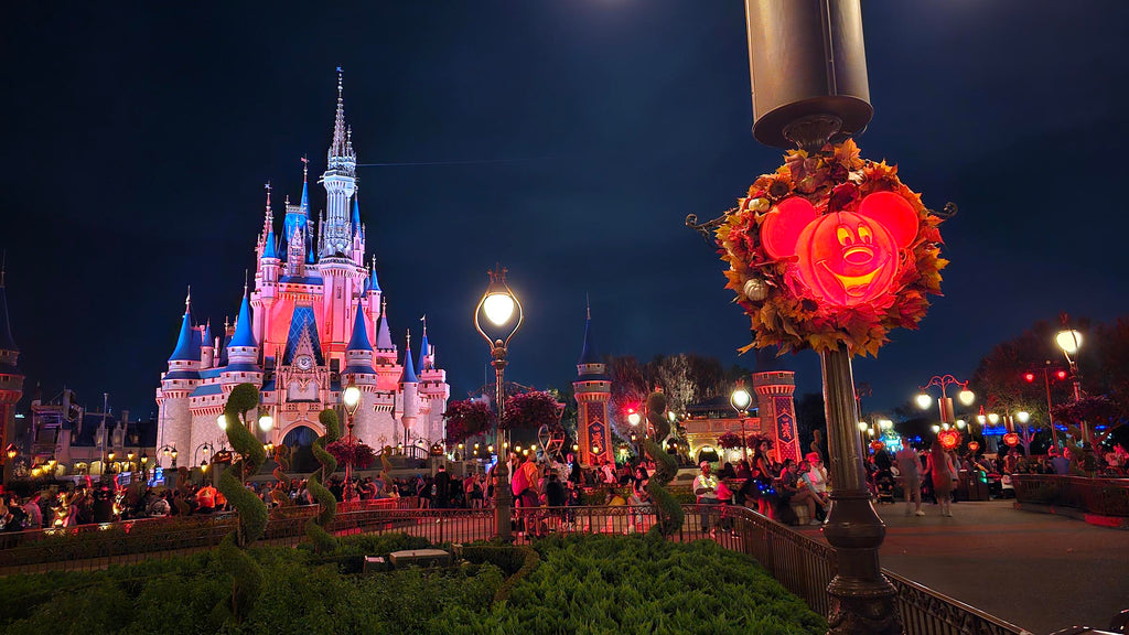 Mickey pumpkin lit up with Cinderella Castle in the background