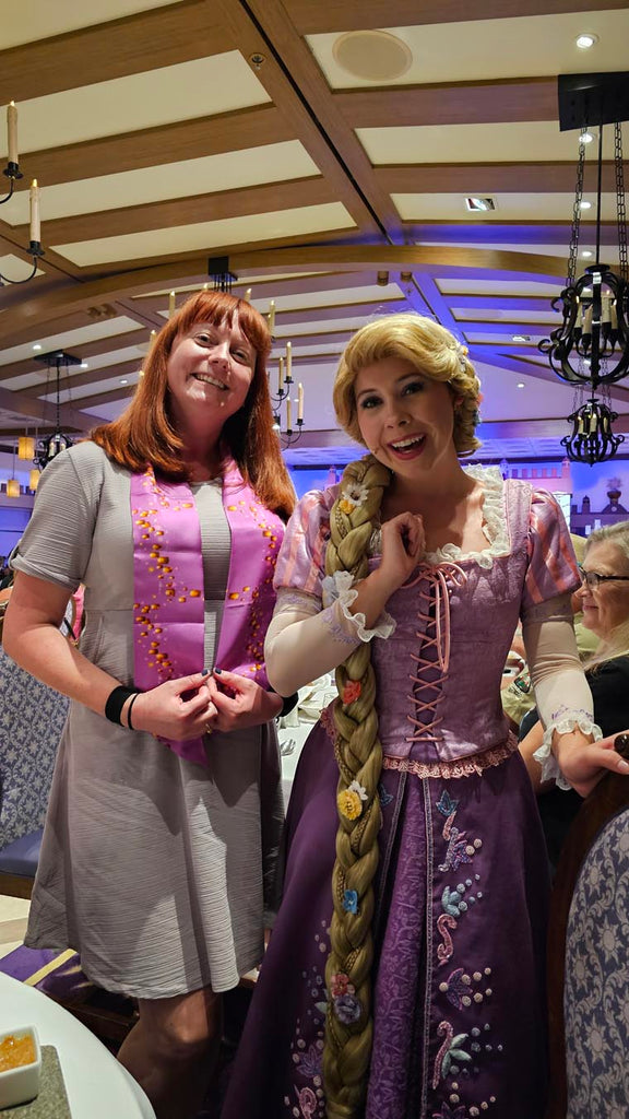Kelly bounding as Rapunzel next to Rapunzel at Rapunzel’s Royal Table on the Disney Magic