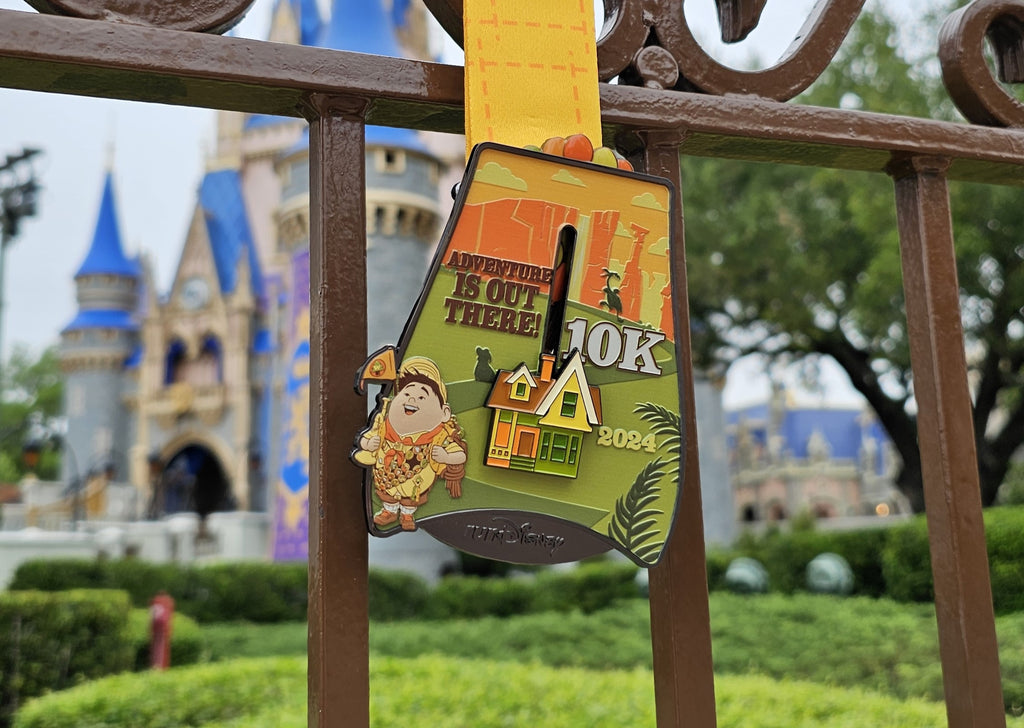 the 2024 RunDisney Springtime Surprise 10K medal with Cinderella Castle in the background