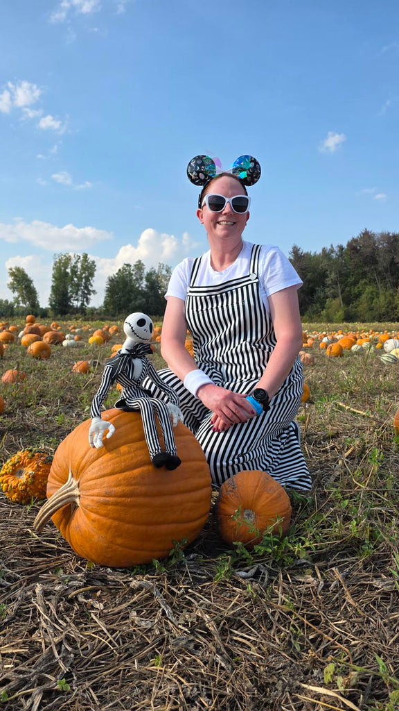 Kelly bounding as Jack Skellington while in a pumpkin patch with a Jack Skellington figurine