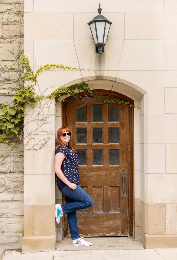 Kelly standing in front of a wooden door reflecting on her thoughts
