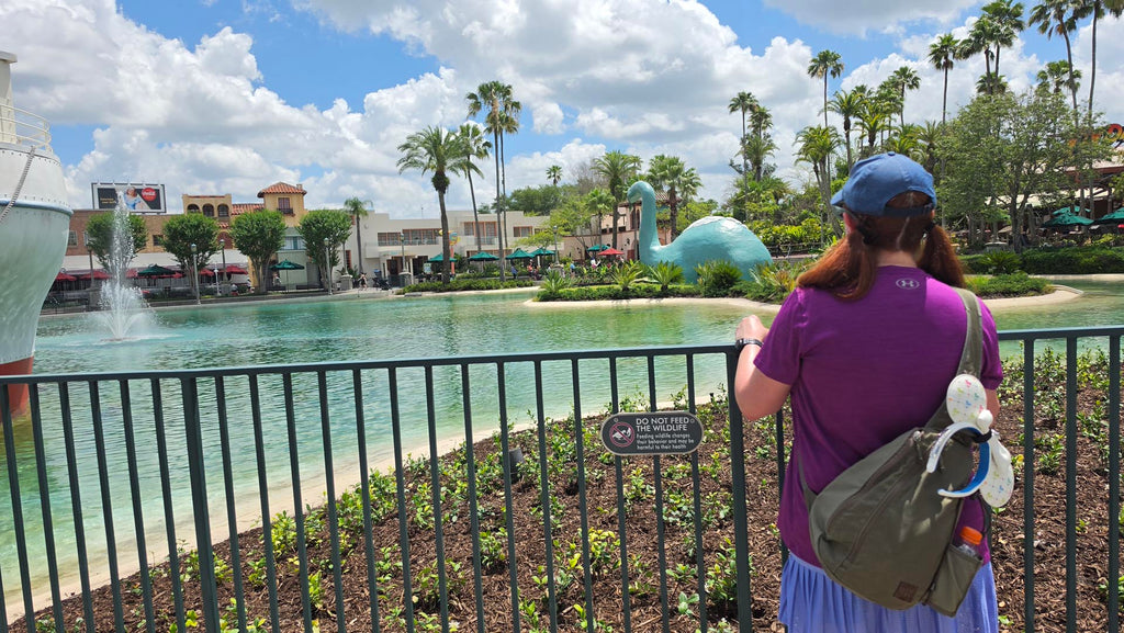Kelly in Disney’s Hollywood Studios looking out at the lake with her park bag hanging on her back