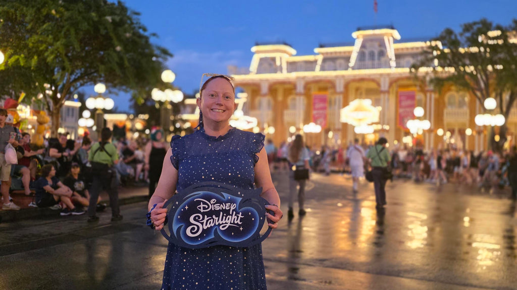 Kelly on Main Street holding sign for the Disney Starlight parade while bounding as the Blue Fairy