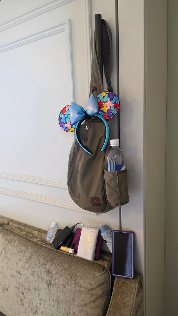 Kelly’s park bag hanging in a studio at Disney’s Saratoga Springs Resort & Spa with the contents of it propped up below