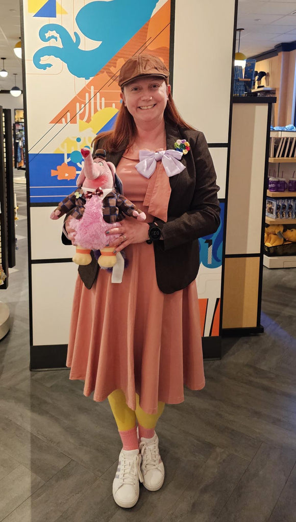 Kelly bounding as Bing Bong at Pixar Place in Disneyland while holding a Bing Bong plush
