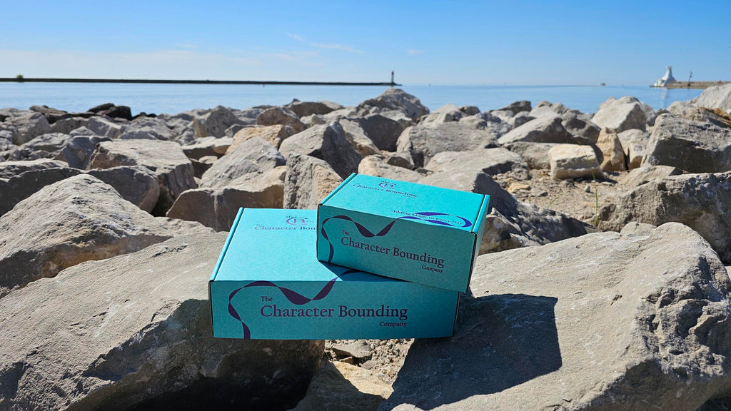 TheCB.Co boxes on rocks in front of a large body of water
