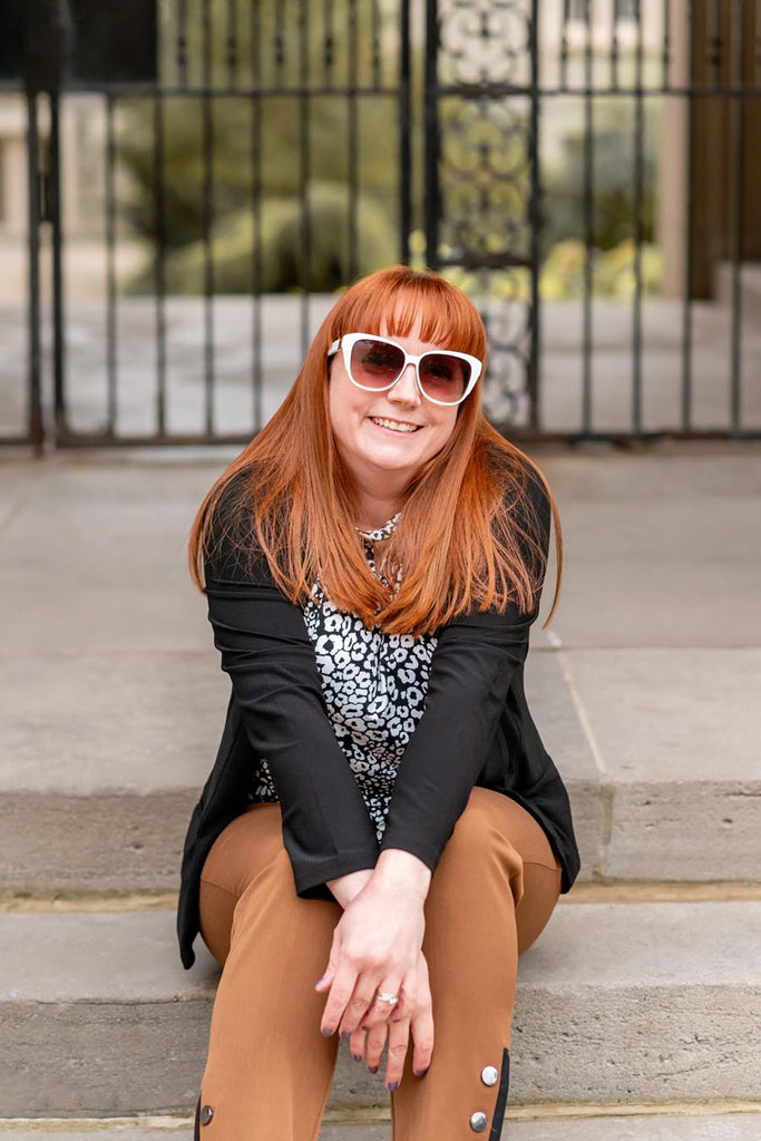 Kelly sitting on steps and smiling at the camera