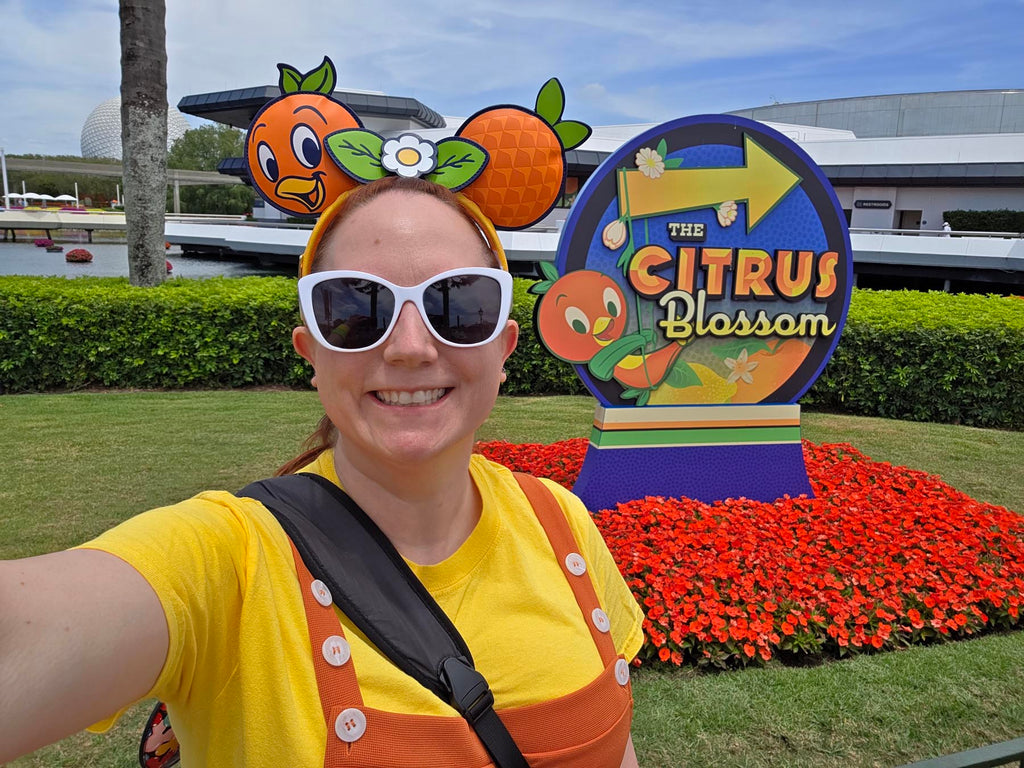 Kelly bounding as Orange Bird in front of the sign for the Citrus Blossom
