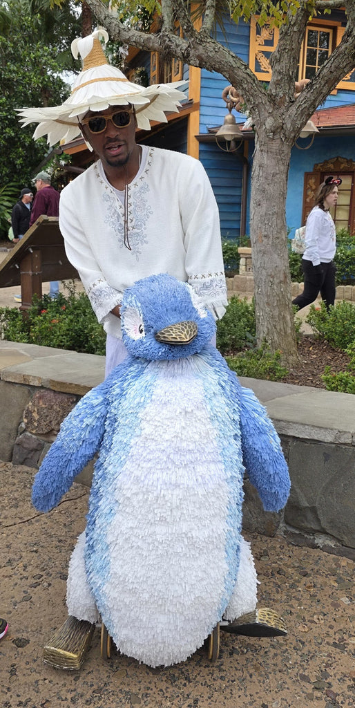 Merry Menagerie performer with giant Penguin puppet at Animal Kingdom