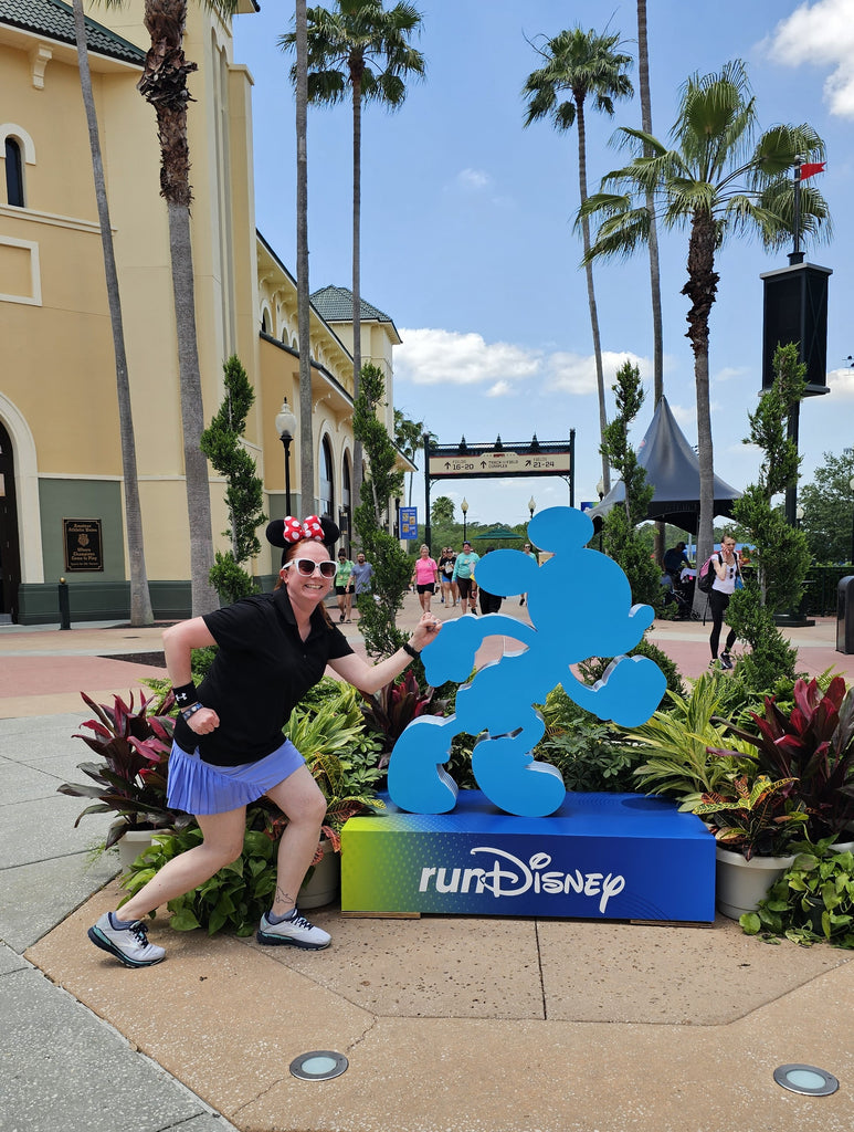 Kelly posing with the Mickey Mouse RunDisney statue