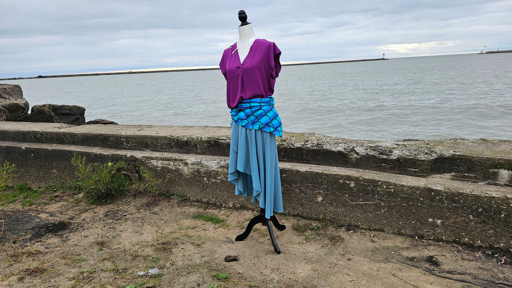 Ariel bound on mannequin with lighthouse and water in the background