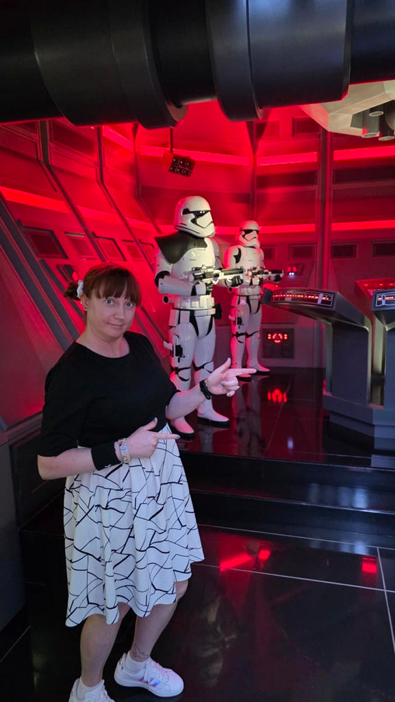Kelly bounding as a Stormtrooper posing in front of 2 Stormtroopers at Star Wars: Galaxy’s Edge in Disney’s Hollywood Studios