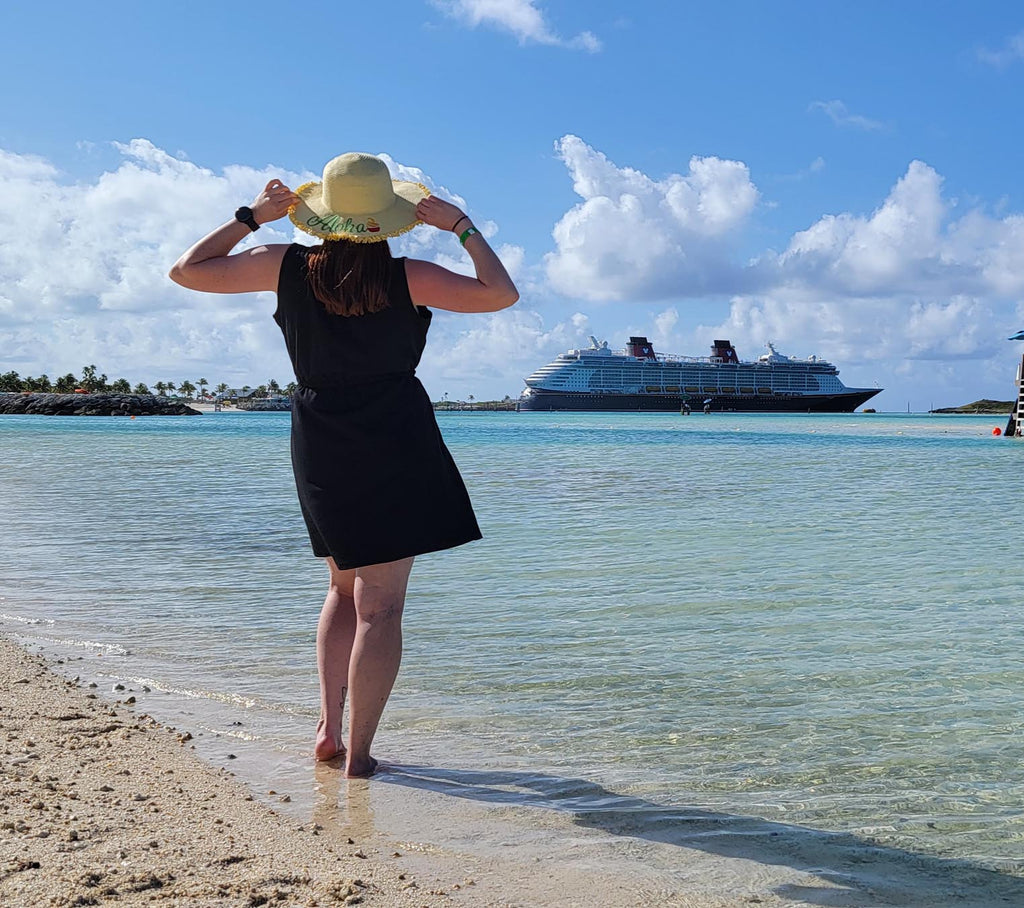 Kelly standing on a beach looking at the Disney Dream